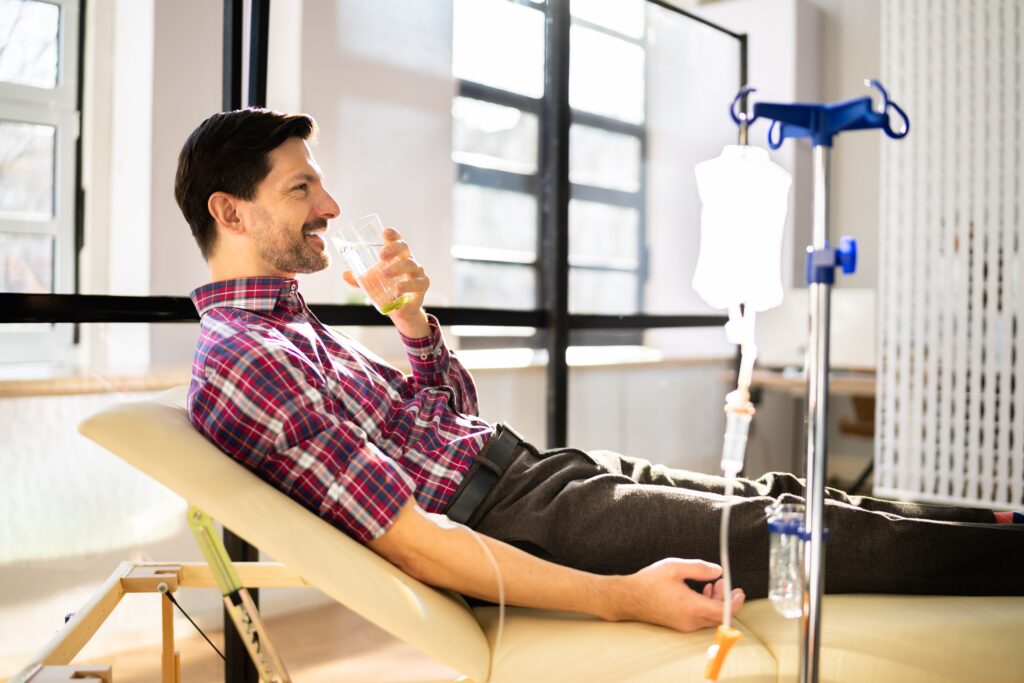 A man sitting in a chair receiving IV therapy for weight loss