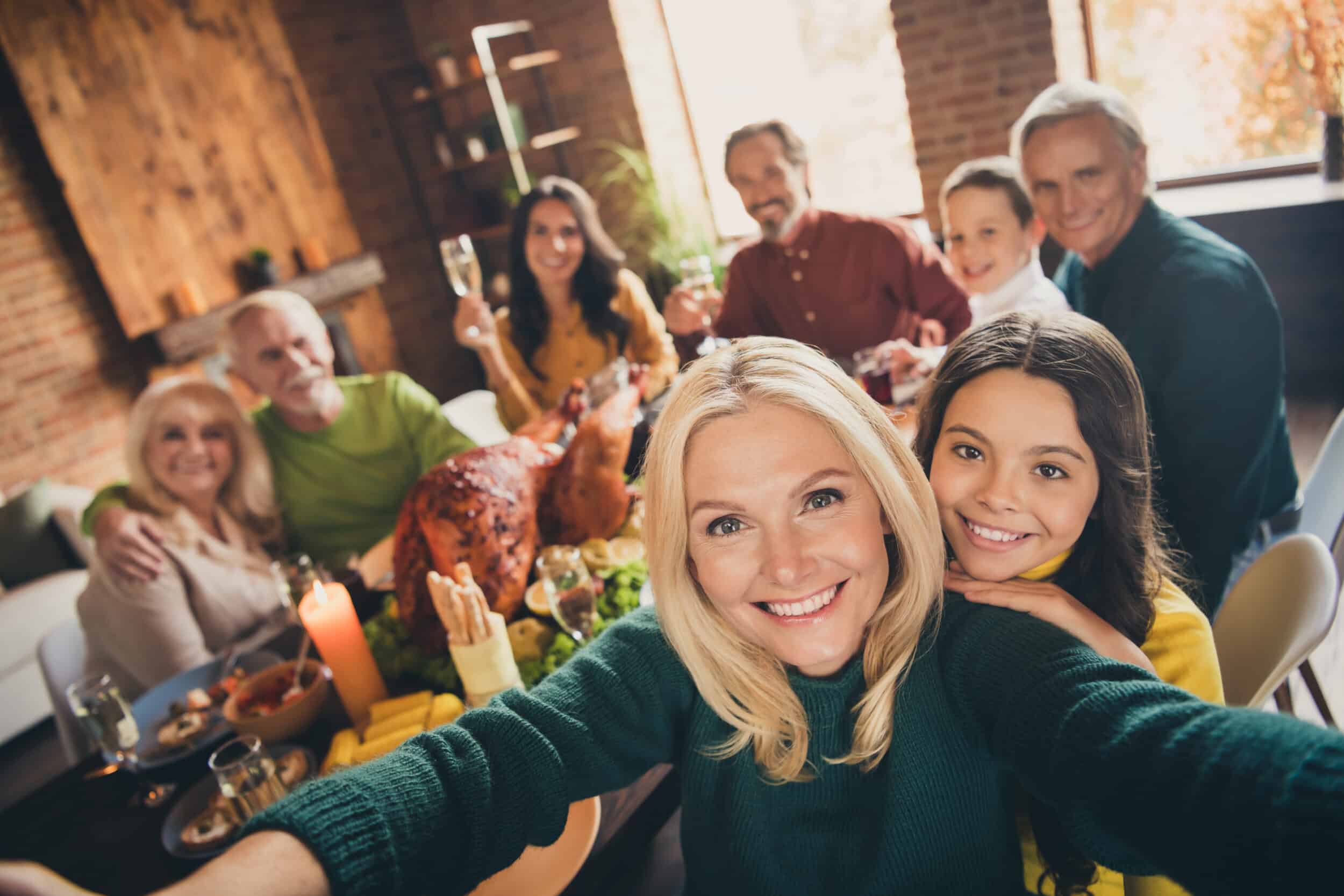 Woman who’s on a weight management program holds a camera for a selfie with her family during the holidays