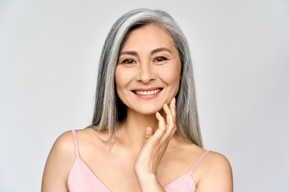 Woman with graying hair and glowing skin, looking youthful after peptide therapy